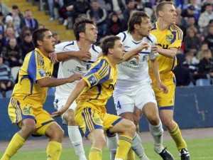 Чернівчани Денис Олійник (в центрі у жовтій формі) та Руслан Платон (№24, біла форма) зійшлися на полі у матчі "Таврія" - "Металіст". Фото сайту Прем'єр-ліги